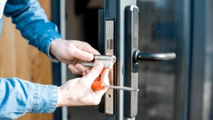 Remplacement de cylindre par un serrurier professionnel Serrurier en train de remplacer un cylindre de serrure sur une porte vitrée.